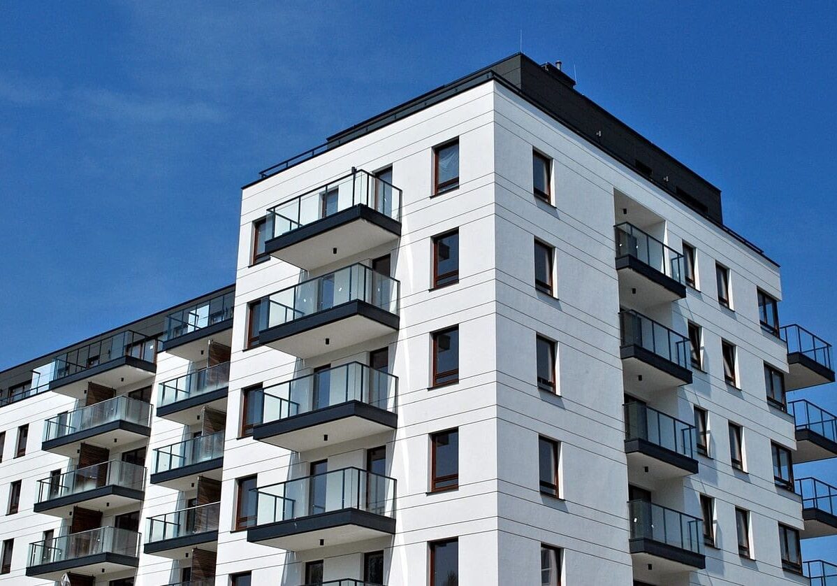 A white building with balconies on the top of it.